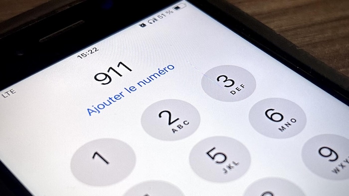Une personne signale le 911 sur son cellulaire.