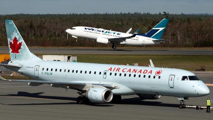 Un avion d'Air Canada et de WestJet sur une piste.