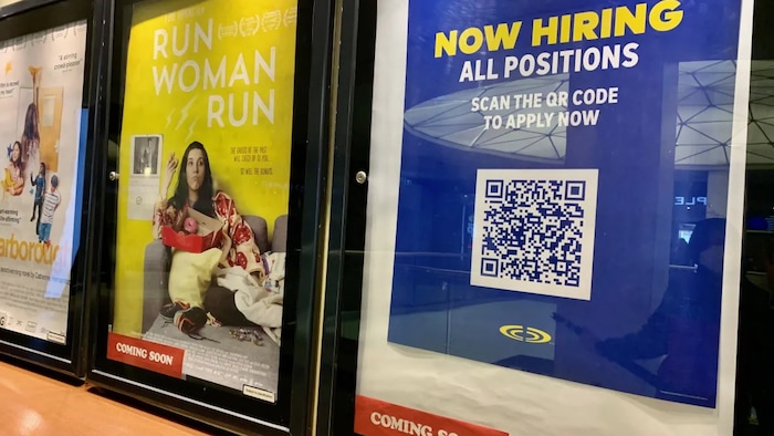 A sign advertising open positions is seen at Cineplex Cinemas Varsity and VIP in Toronto on April 16. Cineplex employs thousands of part-time, teenaged workers and offers perks like free movies. (Brandie Weikle/CBC)