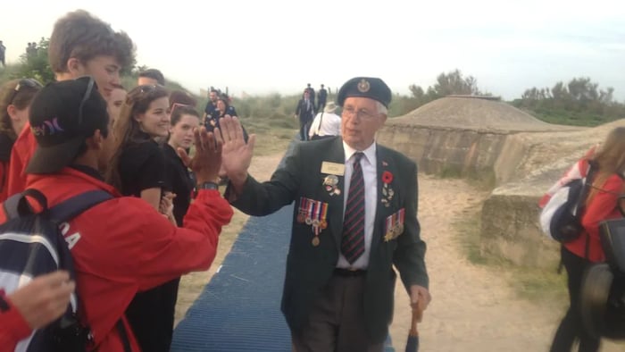 Jim Parks seen in an undated photo high-fiving people at Juno Beach. (Submitted by Jim Parks)