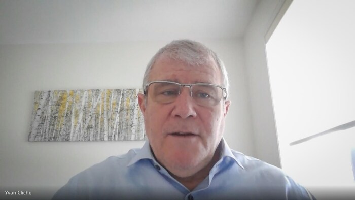 Un homme fixe du regard une caméra.