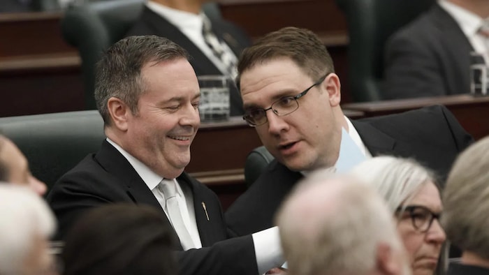Le premier ministre albertain, Jason Kenney (à gauche), et le ministre provincial de l'Environnement, Jason Nixon (à droite), discutent avant le discours du Trône à l'Assemblée législative de l'Alberta, le 21 mai 2019.