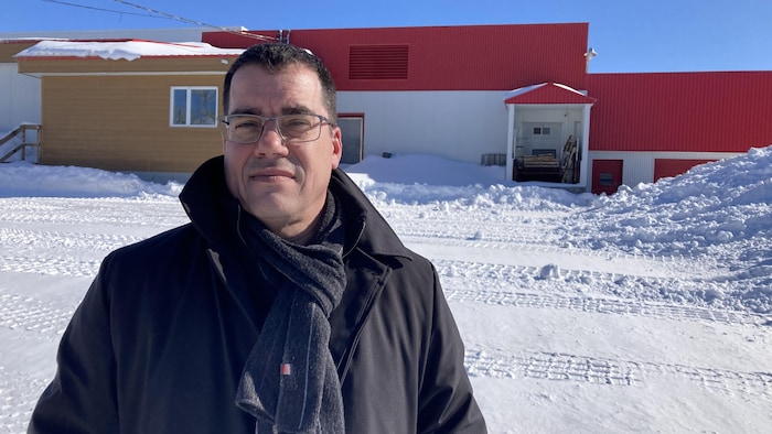 Le préfet devant un bâtiment au toit rouge.