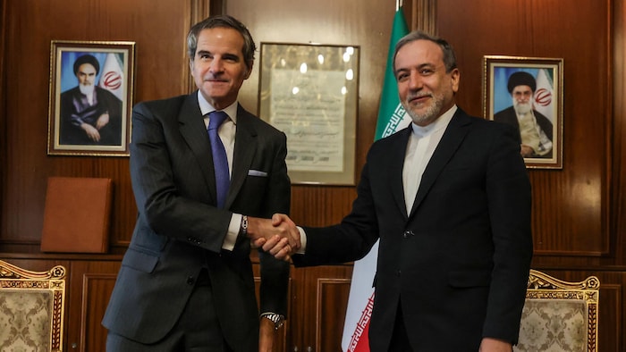 Abbas Araghchi shakes the hand of Rafael magnified in an office.