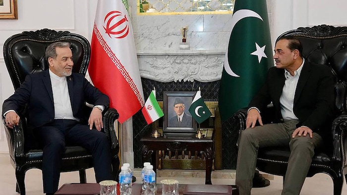  Syed Asim Munir et Abbas Araghchi sont assis devant des drapeaux de l'Iran et du Pakistan.