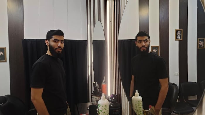 Un jeune homme dans un salon de coiffure.