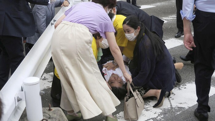 Shinzo Abe gisant au sol, sa chemise tachée de sang.