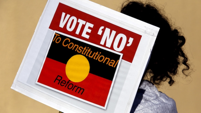 Une manifestante est posée de dos et tient une pancarte lors d'un rassemblement à Sydney en 2015.