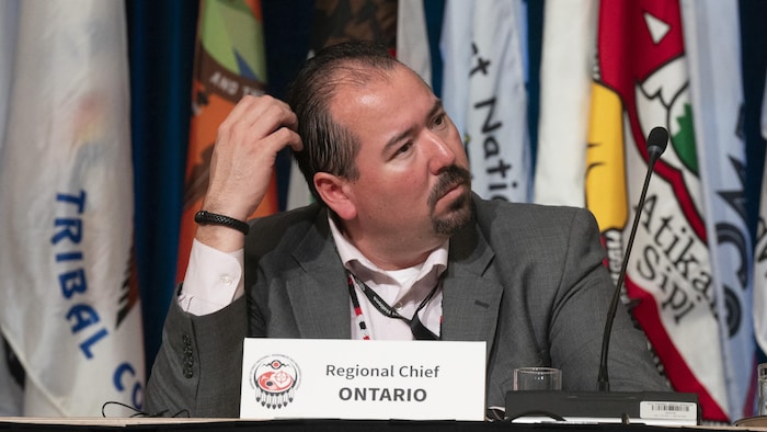 Abram Benedict assis à une table durant une assemblée