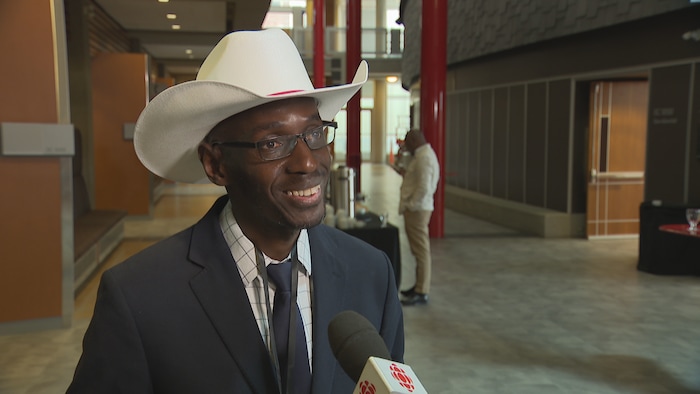 Kazir Coulibaly vêtu d'un chapeau de cowboy accorde une entrevue.