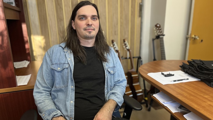 Un musicien est assis à un bureau.