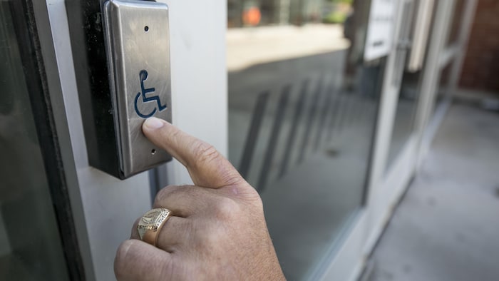 Un bouton pour aider les personnes à mobilité réduite.