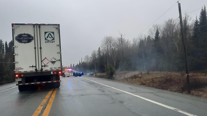 Un camion contourne une voiture de la Sûreté du Québec près du lieu d'un accident sur la route 117.