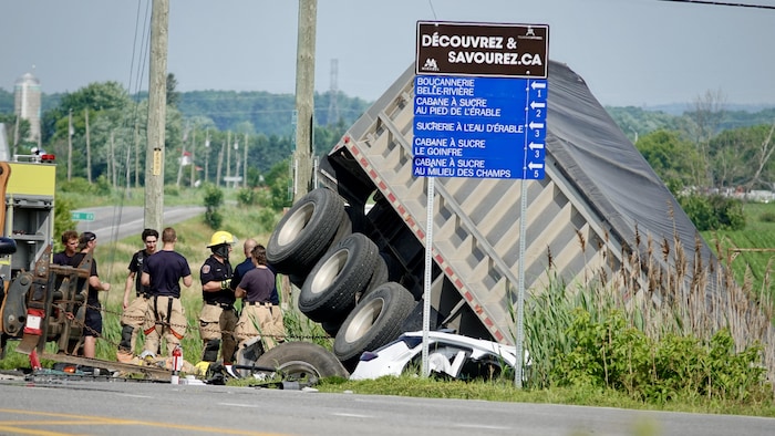 Un semi-remorque et une voiture dans le fossé.