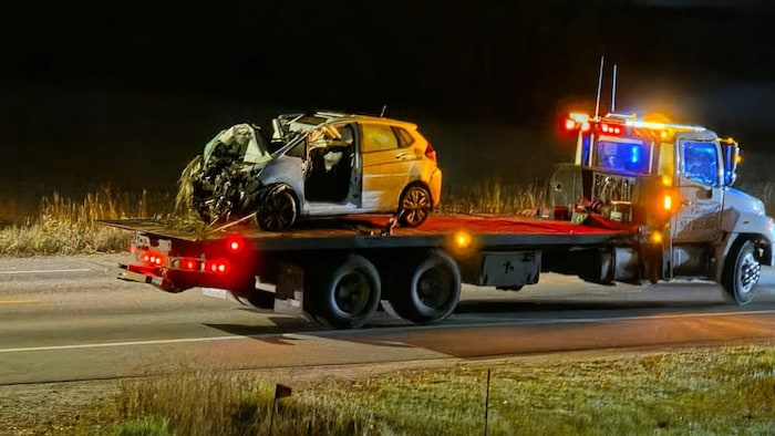 Une voiture est sur un plateforme d'un camion.