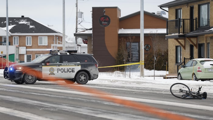 Un vélo accidenté et une voiture de police.