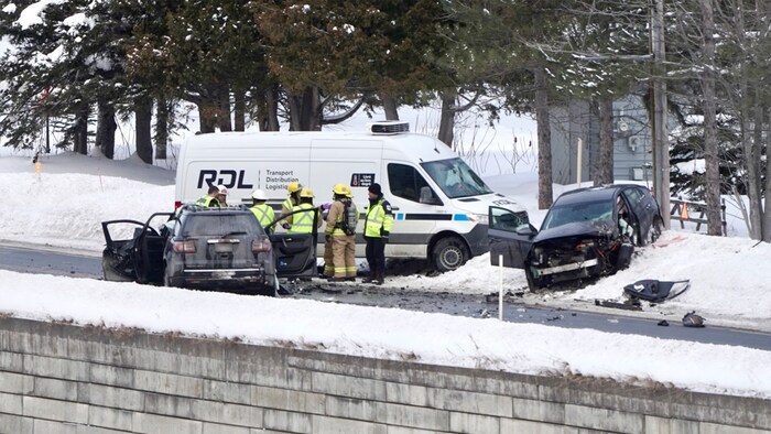 Des premiers intervenants autour d'une voiture accidentée.