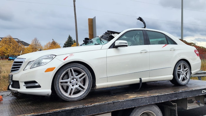 Une automobile blanche dont le toit est enfoncé à la suite d'un accident.