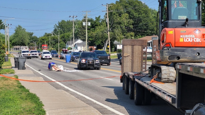 Une scène d'accident où se trouve un quadriporteur renversé sur la chaussée.