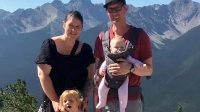 Amber Olson et Shaun Didychuk avec leurs deux filles, Isla et Everly devant des montagnes.