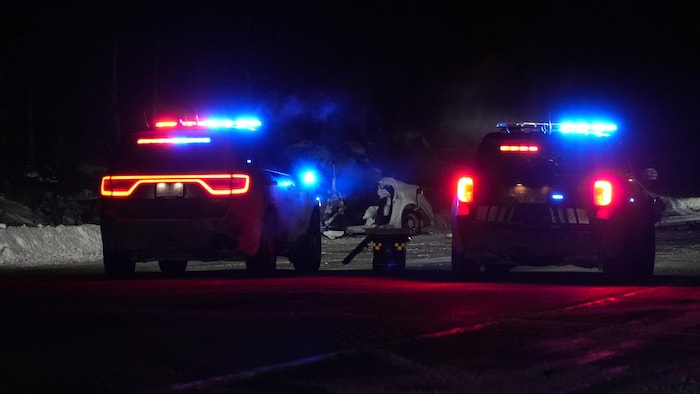 deux véhicules de police, avec à l'arrière un véhicule accidenté. 