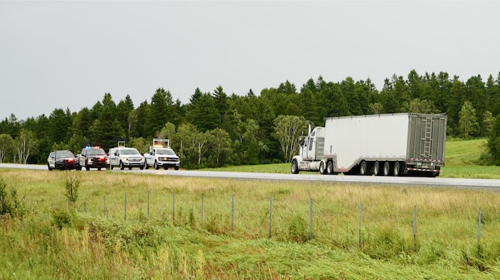 Un camion semi-remorque et des voitures de police.