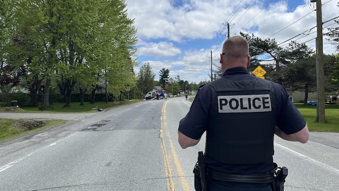 Un policier devant une scène d'accident.
