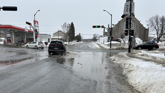 Une voiture circule dans une flaque d'eau.