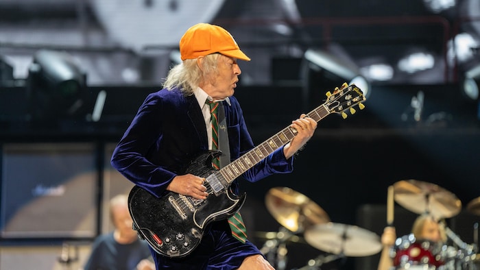 Angus Young qui joue de la guitare.