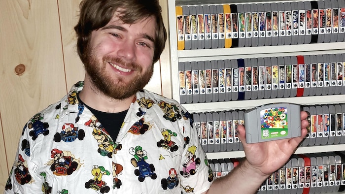 Un homme montre sa collection de jeux vidéo de Nintendo 64.