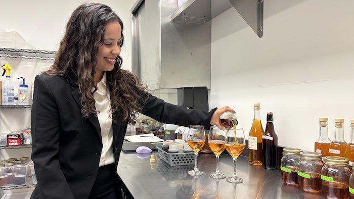 Jaqueline Gilmara Barboza Januário verse du vin d'érable.