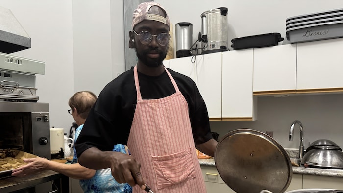 Souleymane Lamine Ndiaye qui cuisine. 