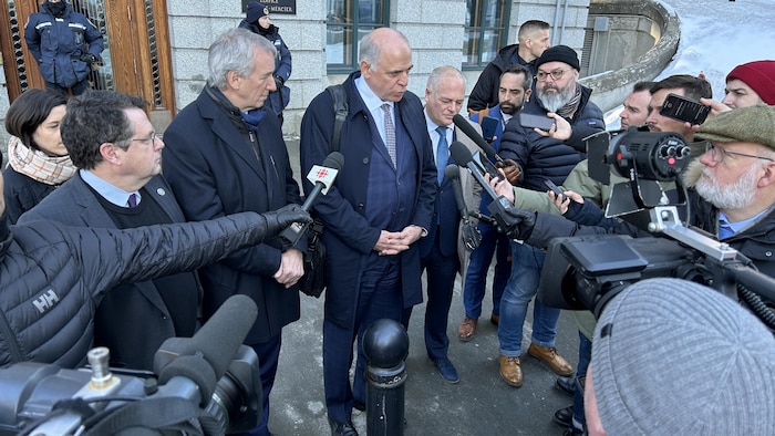 4 hommes s'adressent à une dizaine de journalistes.