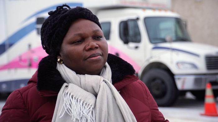 Portrait de Josiane Seri devant le camion de la clinique mobile.