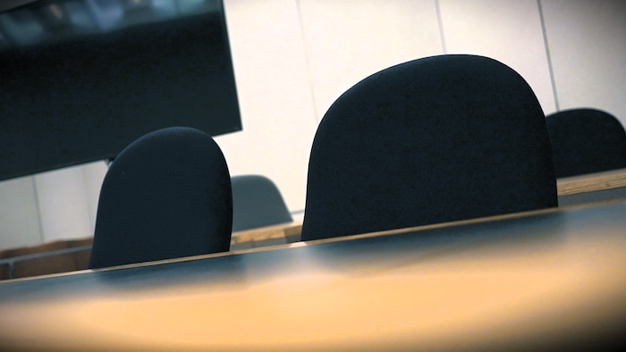Des fauteuils vides dans une salle d'audience du palais de justness  de Montréal.