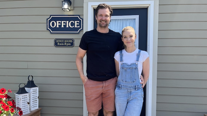 Adam Lowther et Audrey-Anne Jean sont debout devant l'entrée de leur propriété.