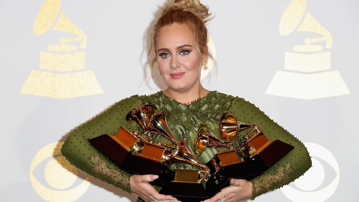 La chanteuse tient cinq trophées Grammy dans ses bras.