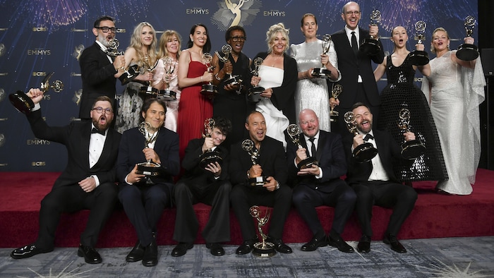De nombreuses personnes tiennent des trophées.