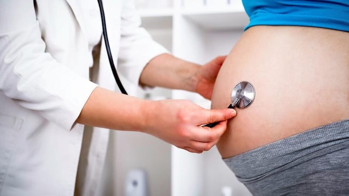 طبيبة تقوم بمعاينة امرأة حامل.