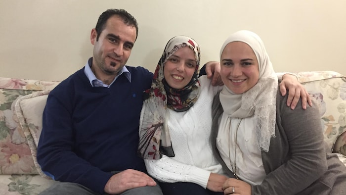 ثلاثة أشخاص يجلسون على أريكة.
