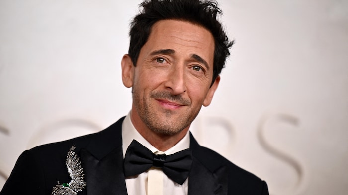 Un homme sourit à moitié.     