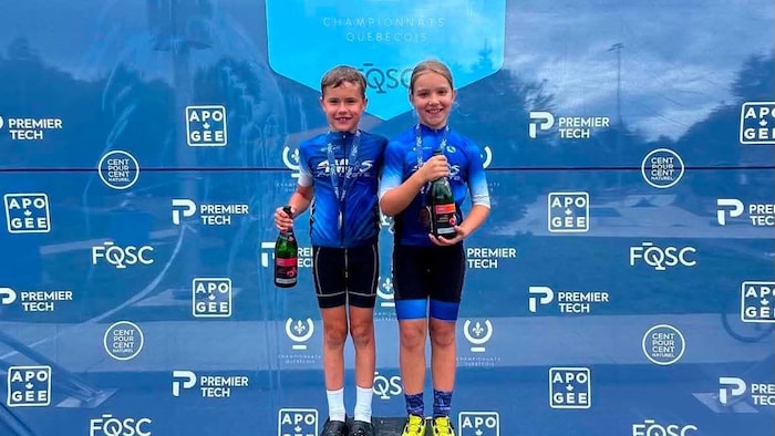 Deux jeunes enfants posent pour la photo sur un podium.