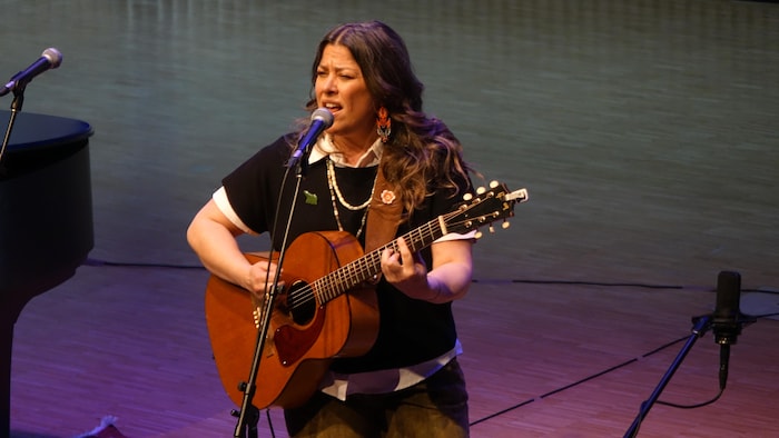 Adrina Turenne joue de la guitare et chante. 