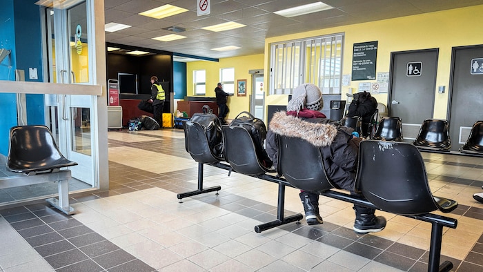 Un enfant est assis sur une chaise dans un terminal. 