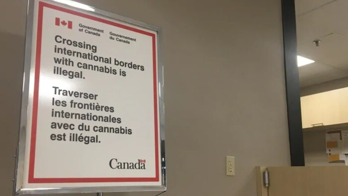 Une affiche indique : « Traverser les frontières internationales avec du cannabis est illégal. »