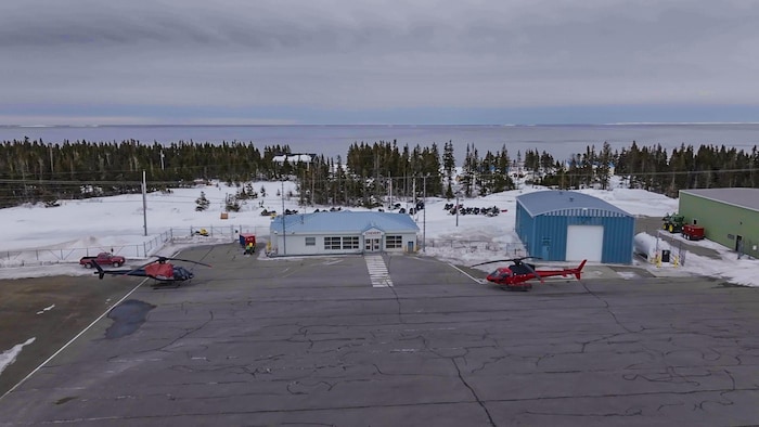 Point de vue aérien de l'aéroport de Chevery. Bâtiments et hélicoptères.