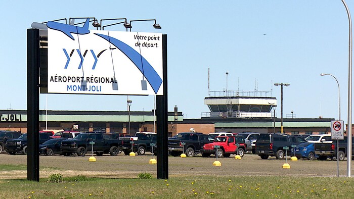L'affiche de l'aéroport et des bâtiments derrière.