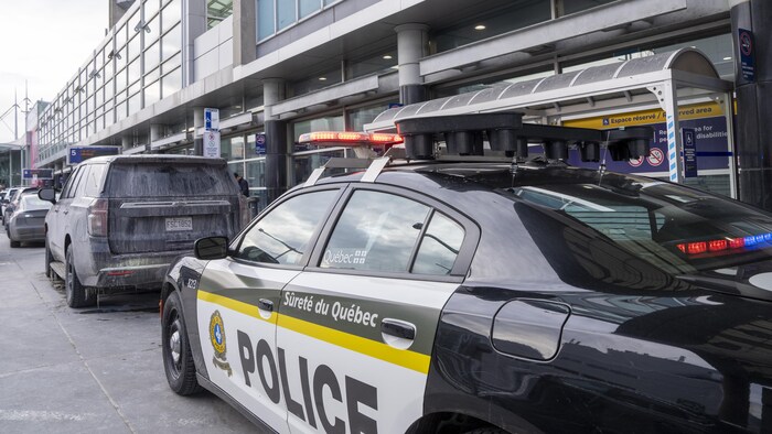 Une voiture de la Sûreté du Québec stationnée devant l'aéroport Montréal-Trudeau.