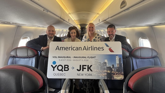 Quatre personne dans un avion tenant un billet d'avion géant.