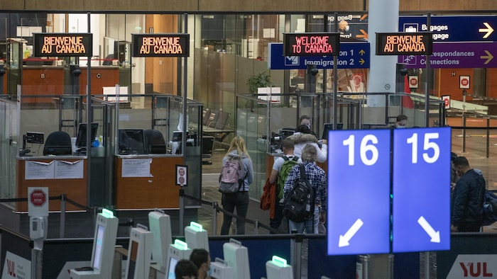 Des passagers arrivent au contrôle frontalier à l’aéroport international Trudeau à Montréal pour les formalités d’entrée au pays.